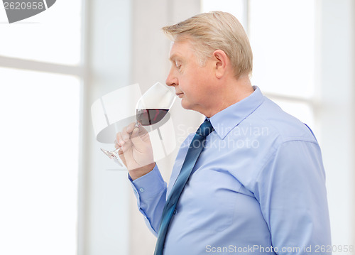 Image of older man smelling red wine