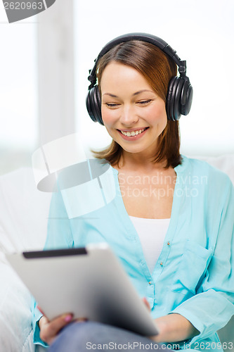 Image of smiling woman with tablet pc and headphones