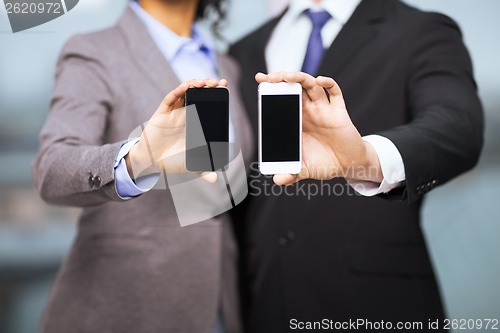 Image of businessman and businesswoman with smartphones
