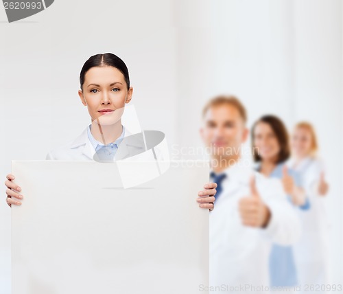 Image of calm female doctor with white blank board