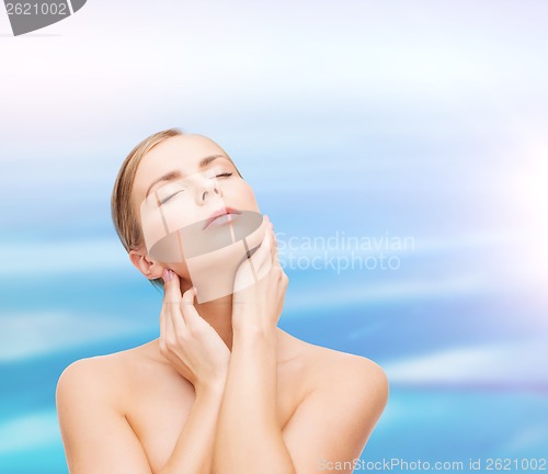 Image of beautiful woman touching her face with closed eyes