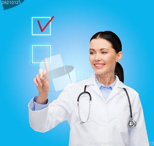 Image of smiling female doctor pointing to checkbox