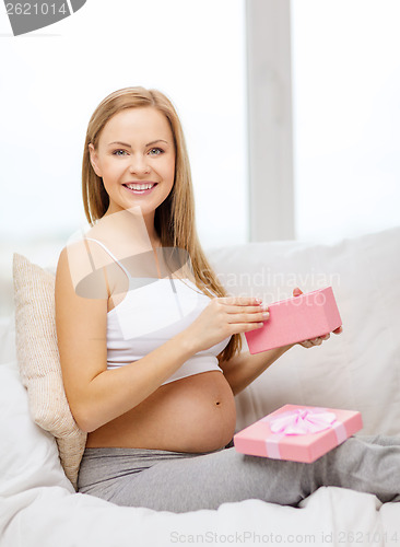 Image of smiling pregnant woman with opened gift box