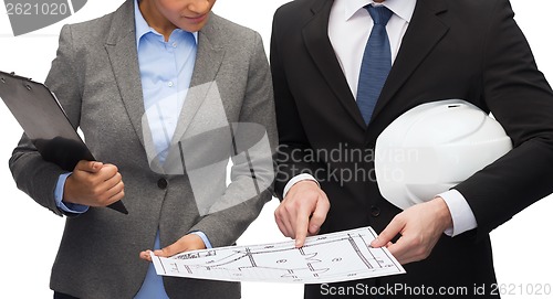 Image of businesspeople with blueprint and helmet