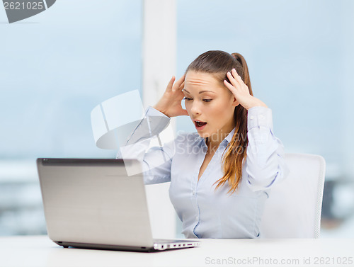 Image of stressed woman with laptop