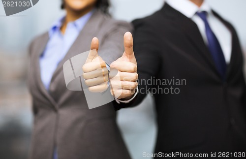 Image of businessman and businesswoman showing thumbs up