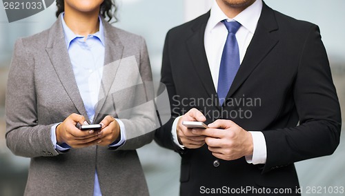 Image of businessman and businesswoman with smartphones