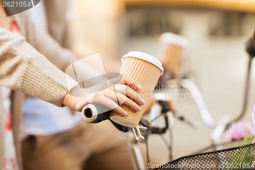 Image of woman hand holding coffee and riding bicycle