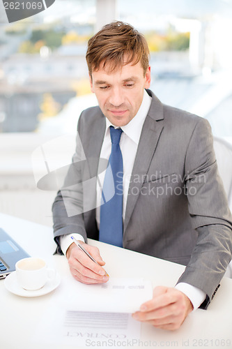Image of businessman with laptop computer and documents