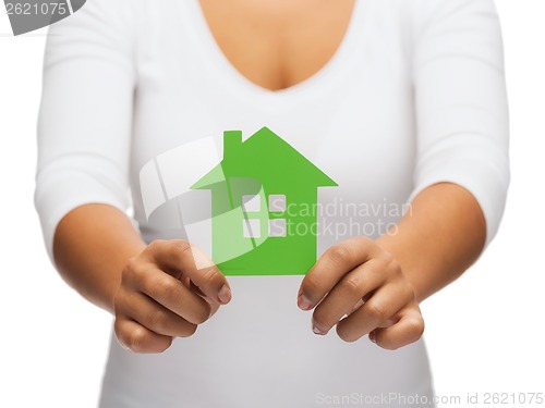 Image of woman hands holding green house