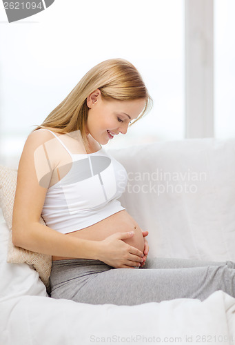 Image of happy pregnant woman touching her belly