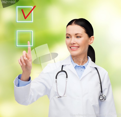 Image of smiling female doctor pointing to checkbox