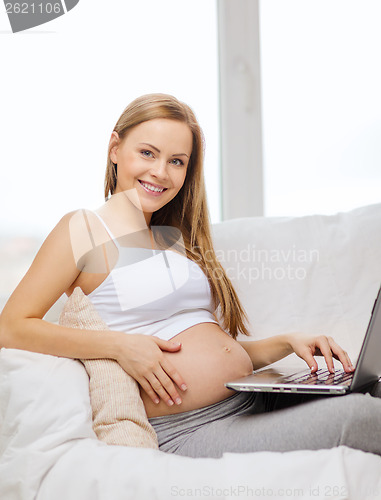 Image of smiling pregnant woman with laptop computer