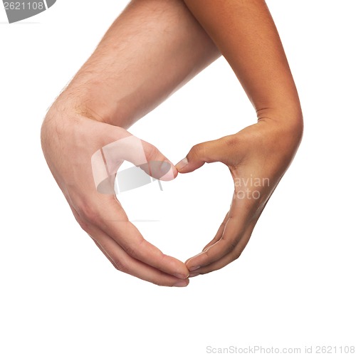 Image of woman and man hands showing heart shape