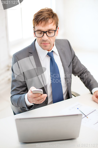 Image of businessman working with laptop and smartphone