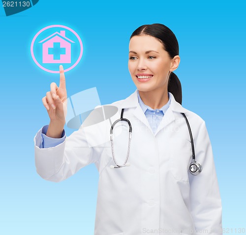 Image of smiling female doctor pointing to hospital sign