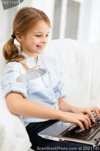 Image of smiling girl with laptop computer at home