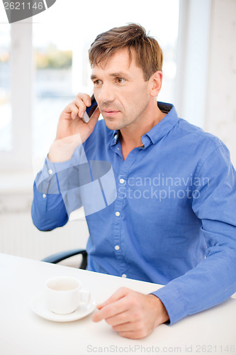 Image of buisnessman with cell phone and cup of coffee