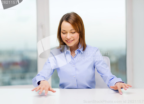 Image of smiling woman pointing to something imaginary