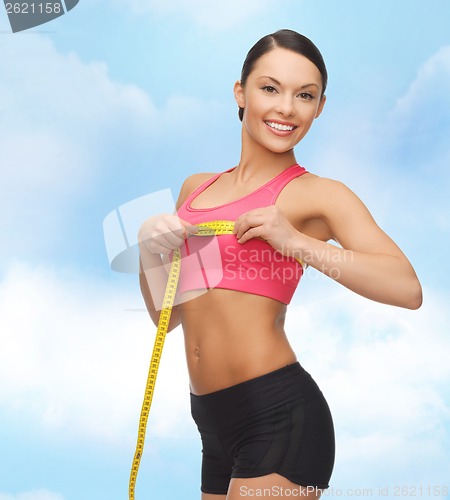 Image of sporty woman measuring her breast