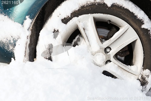 Image of closeup of car wheel stuck in snow