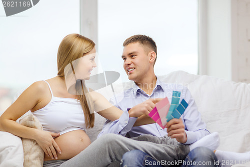 Image of expecting parents choosing color for nursery
