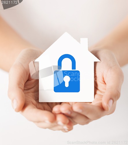 Image of hands holding paper house with lock