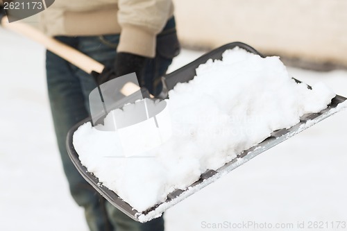 Image of closeup of man shoveling snow from driveway