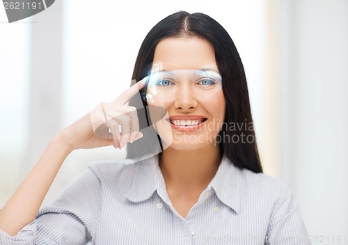 Image of smiling woman pointing to futuristic glasses