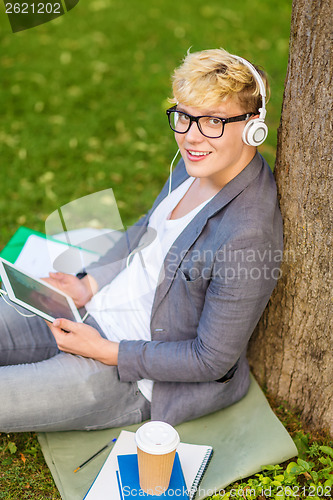 Image of boy with headphones, tablet pc, books and coffee