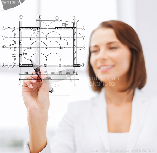 Image of female architect drawing blueprint