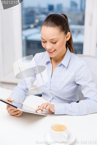 Image of smiling businesswoman with tablet pc in office