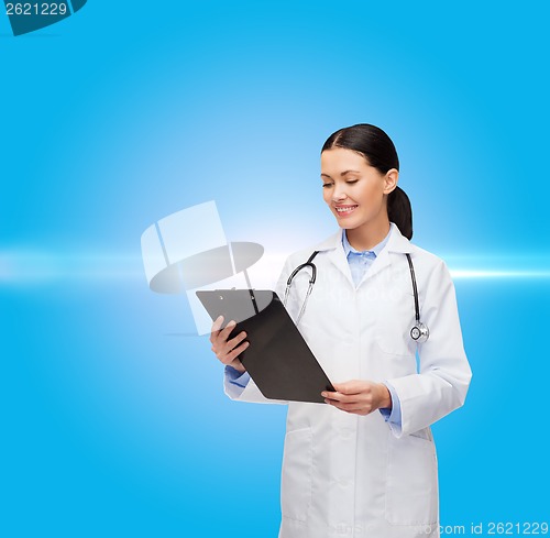 Image of smiling female doctor with clipboard