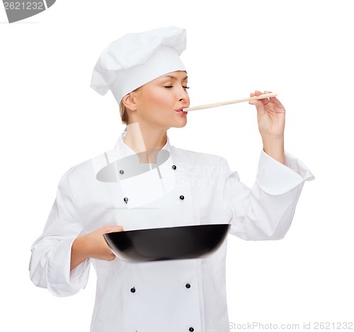 Image of smiling female chef with pan and spoon