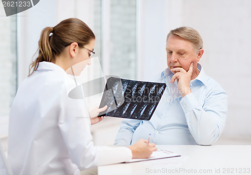 Image of female doctor with old man looking at x-ray