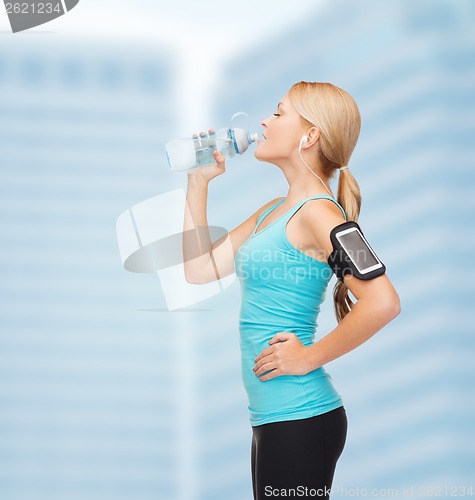 Image of sporty woman running with smartphone and earphones