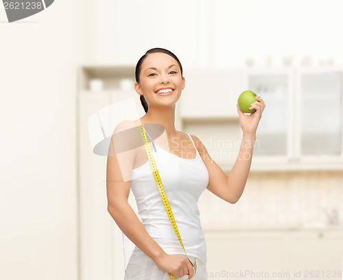Image of sporty woman with apple and measuring tape