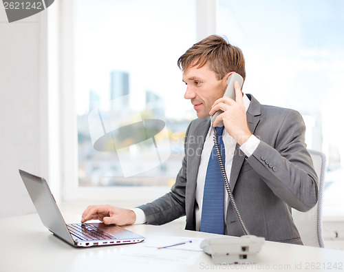 Image of businessman with laptop computer and phone