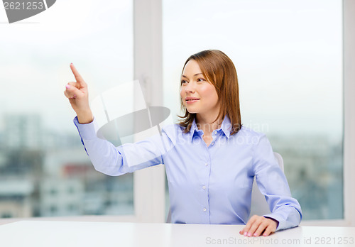 Image of smiling woman pointing to something imaginary