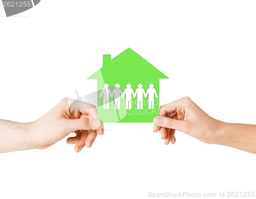 Image of man and woman hands with paper house