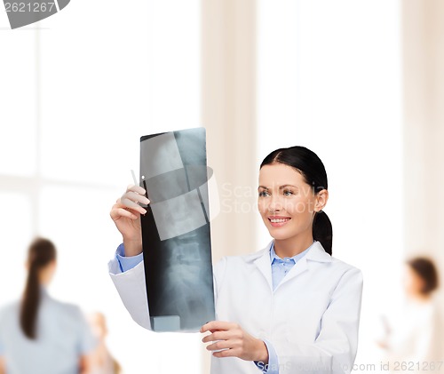 Image of smiling female doctor looking at x-ray