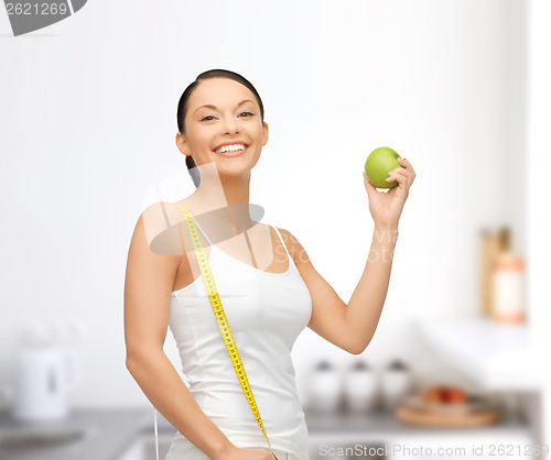 Image of sporty woman with apple and measuring tape