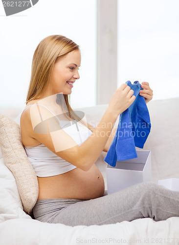 Image of smiling pregnant woman opening gift box