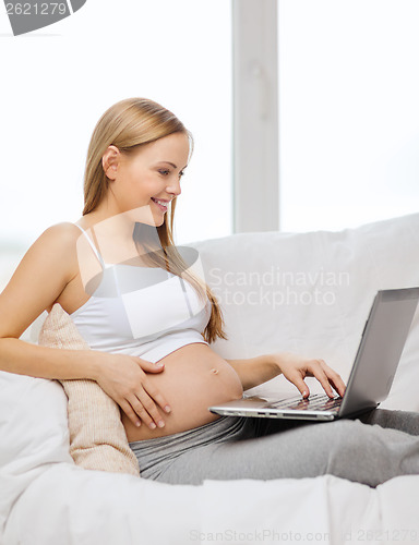 Image of smiling pregnant woman with laptop computer