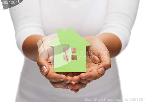 Image of woman hands holding green house