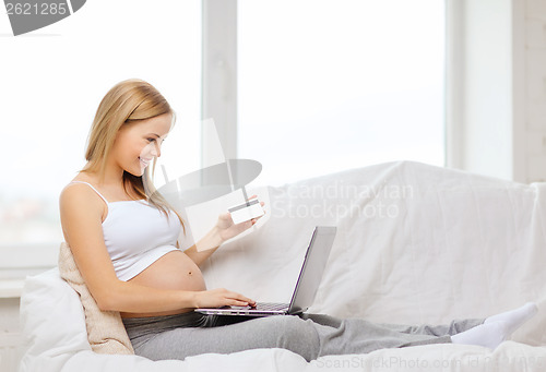 Image of smiling pregnant woman with laptop computer