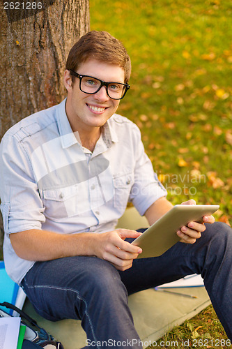 Image of smiling male student in eyeglasses with tablet pc