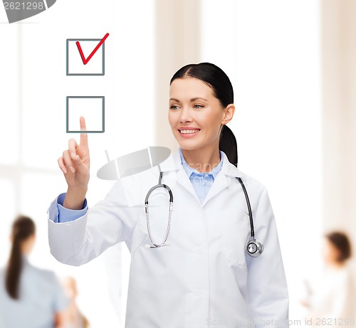 Image of smiling female doctor pointing checkbox