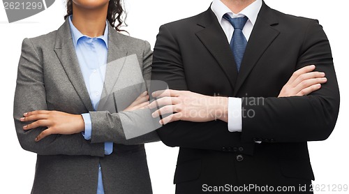 Image of businesswoman and businessman with crossed arms