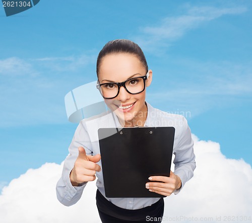 Image of smiling businesswoman in eyeglasses with clipboard